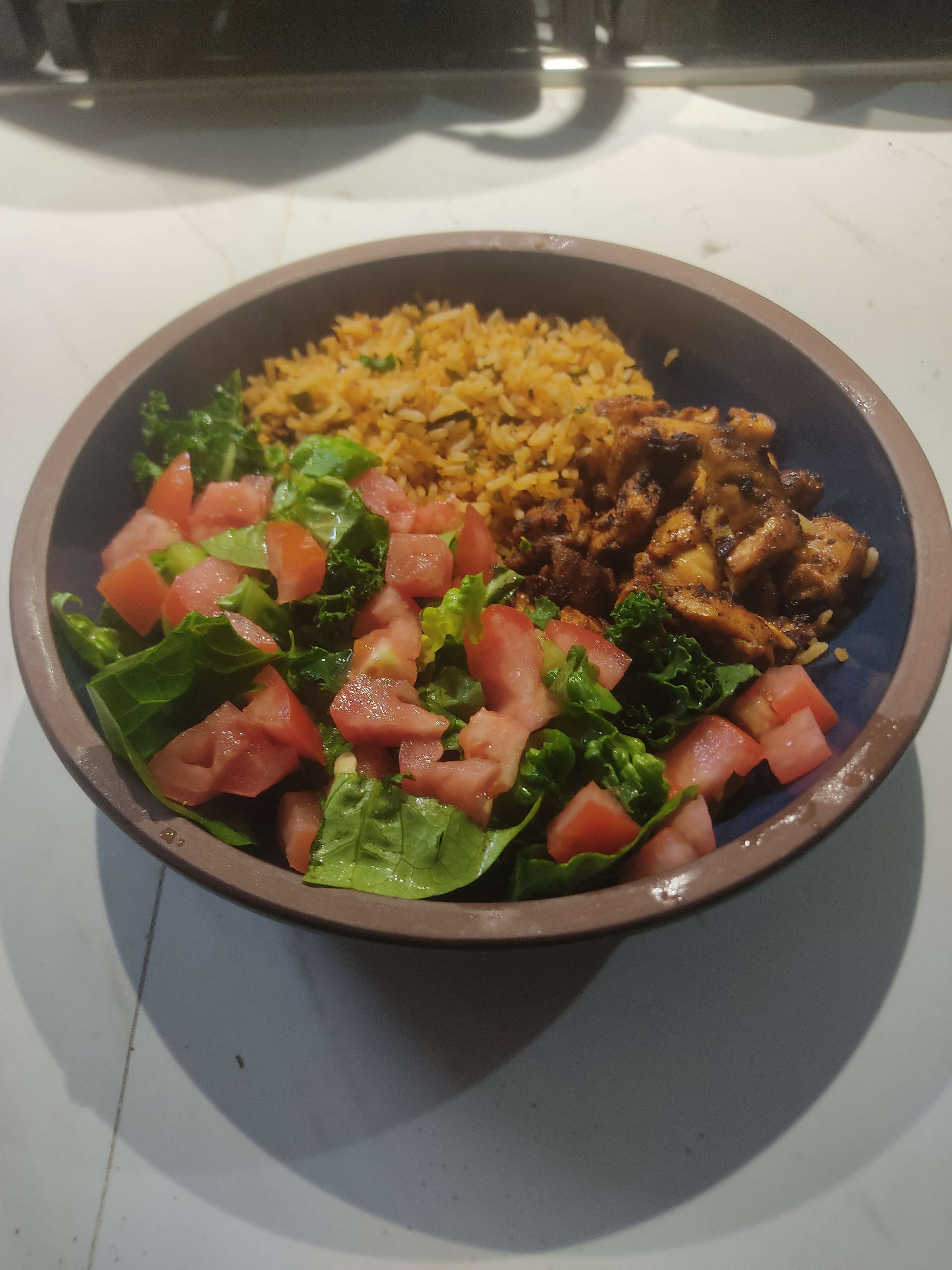 Plate of chicken thighs with rice and a simple salad